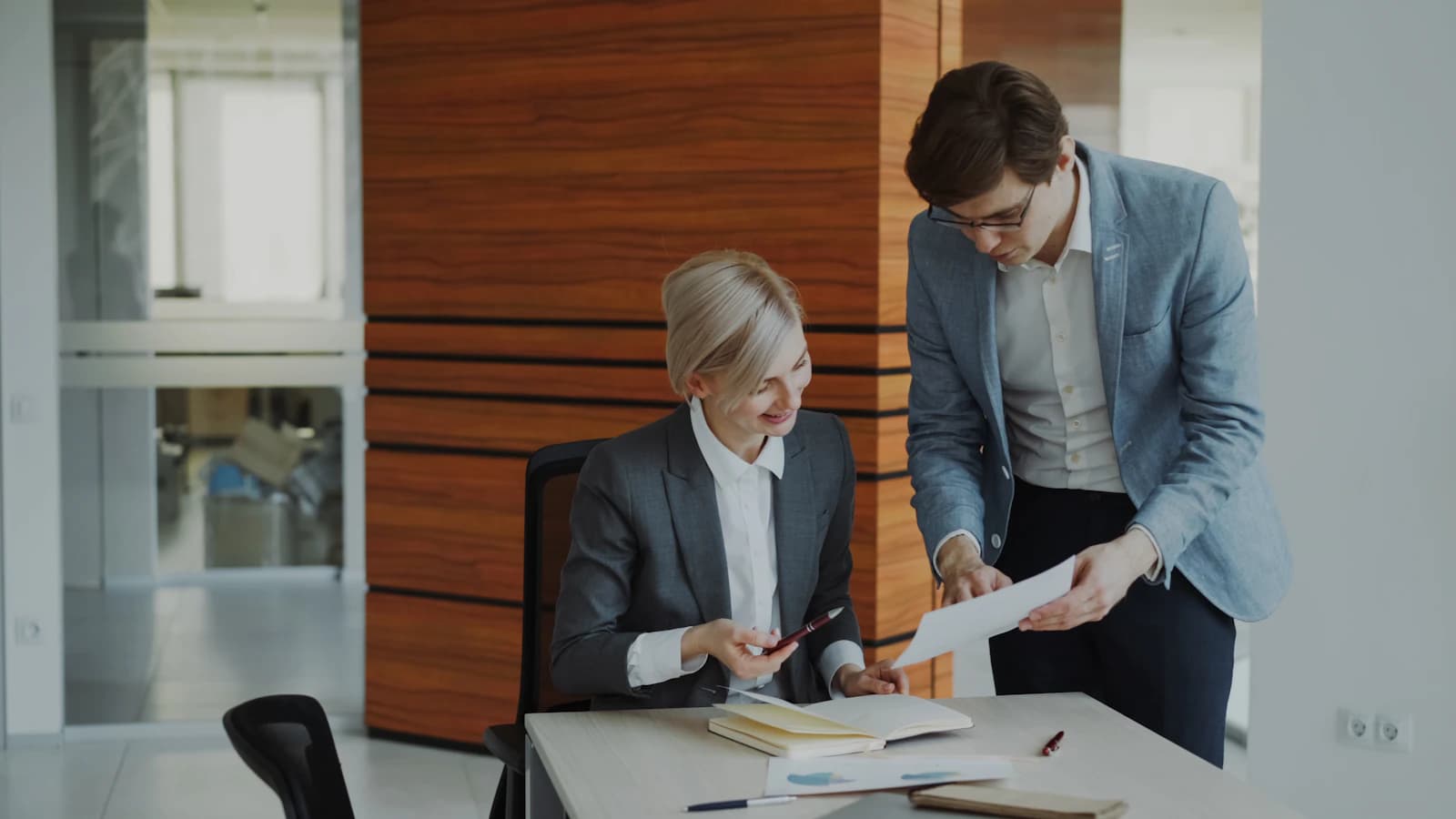 Colleagues discussing documents at an office desk